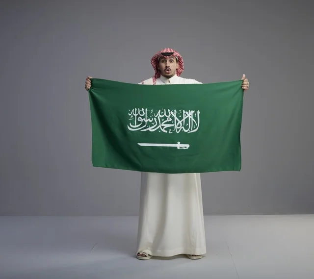 Saudi Man Holding Saudi Arabia National Flag in Studio