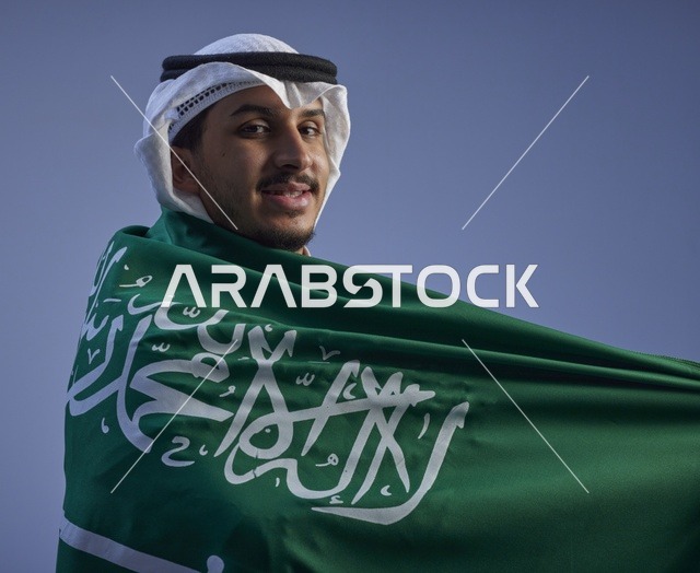 شاب سعودي يرتفع بالعلم السعودي في اليوم الوطني