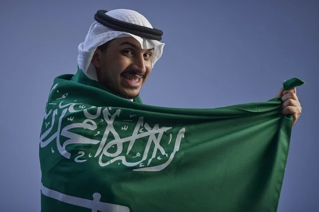 شاب سعودي يرتدي العلم السعودي في اليوم الوطني