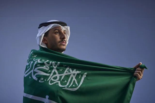 شاب سعودي يلتف بالعلم السعودي في احتفالات اليوم الوطني