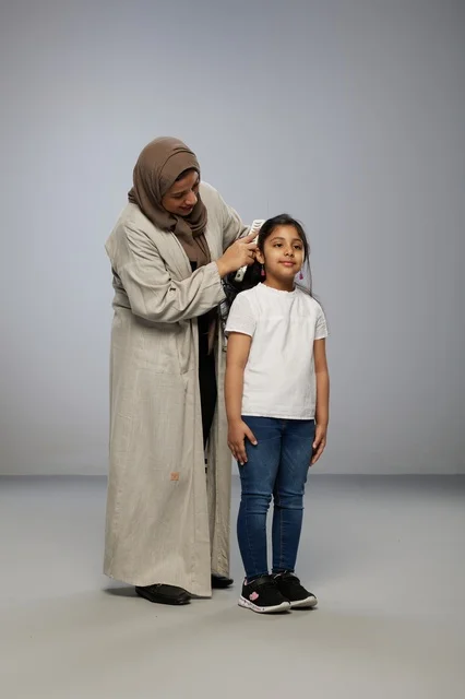 Saudi Mother Combing Daughter's Hair in Studio Saudi Mother Combing Daughter's Hair in Studio