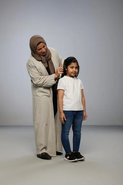 Saudi Mother Combing Daughter's Hair in Studio