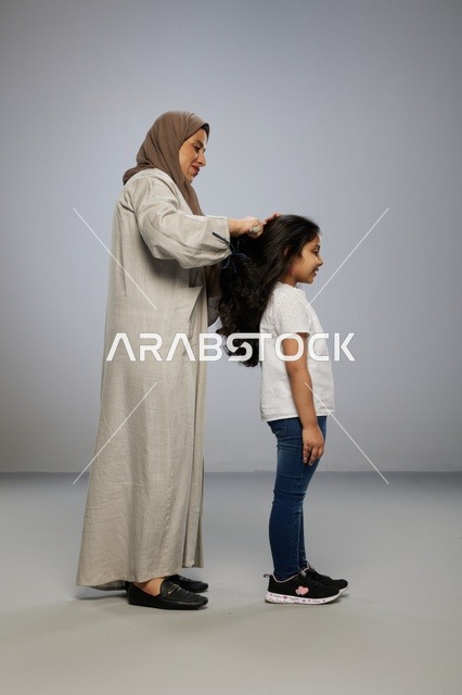 أم سعودية تمشط شعر ابنتها في استوديو احترافي