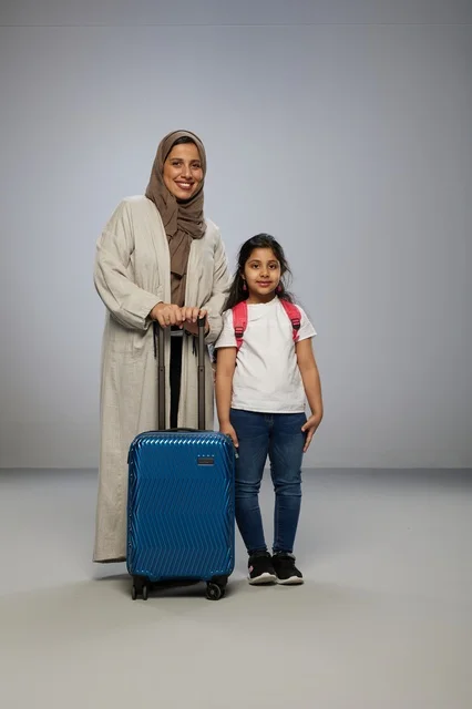 Saudi Mother and Daughter with Blue Suitcase for Travel