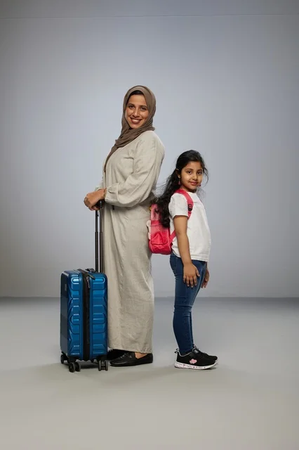Saudi Mother and Daughter Traveling with Suitcase