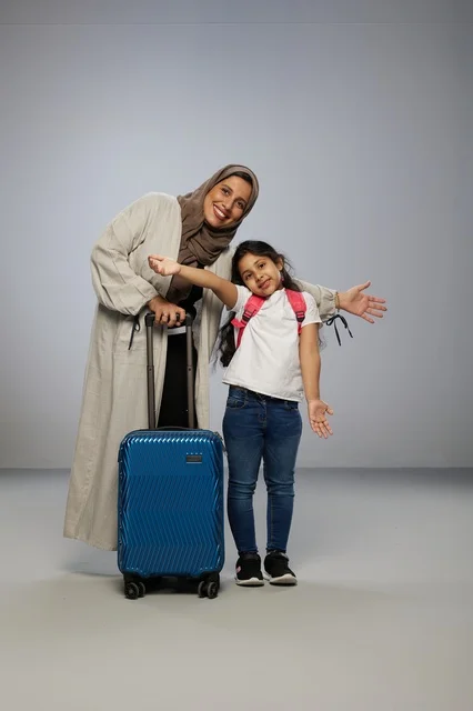 أم وابنتها سعوديتان مع حقيبة سفر للسياحة