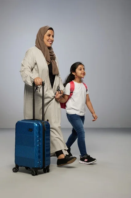 Saudi Mother and Daughter Traveling with Blue Suitcase