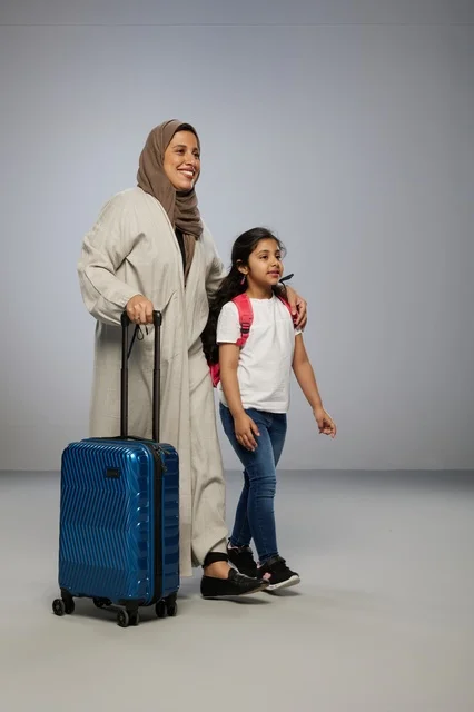 Saudi Mother and Daughter Traveling with Blue Suitcase