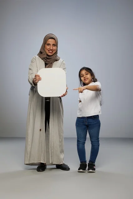 أم وابنة سعودية تحملان لوحة بيضاء فارغة