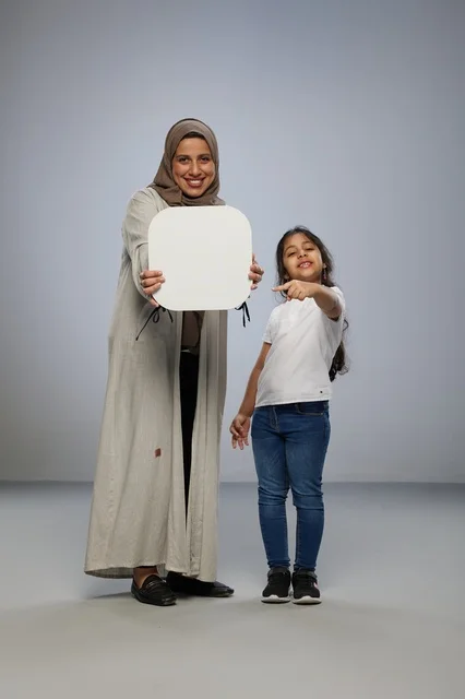 أم وابنة سعودية تمسكان بلوحة بيضاء فارغة