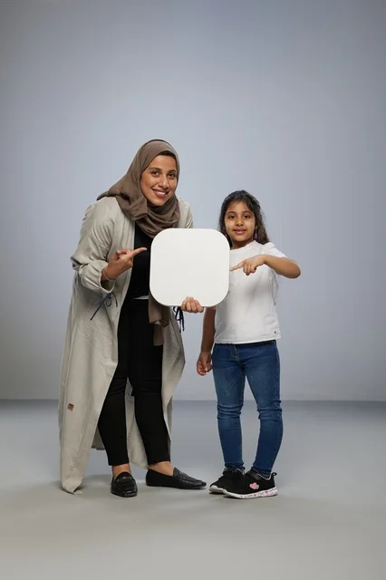 Saudi Mother and Daughter Holding Blank White Sign Board
