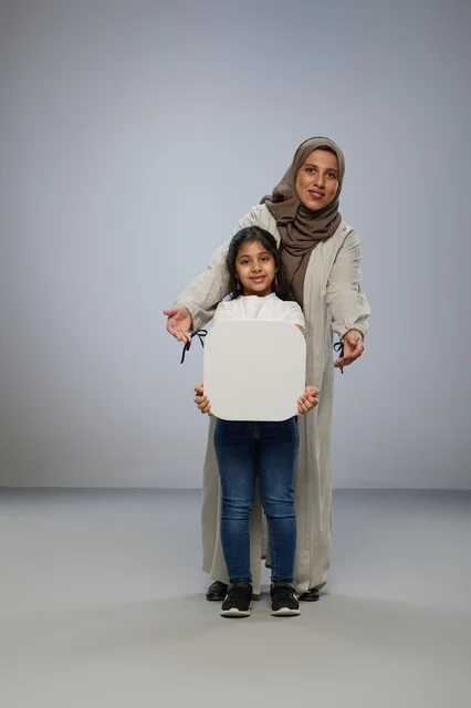 أم وابنتها سعوديتان تمسكان بلوحة بيضاء فارغة