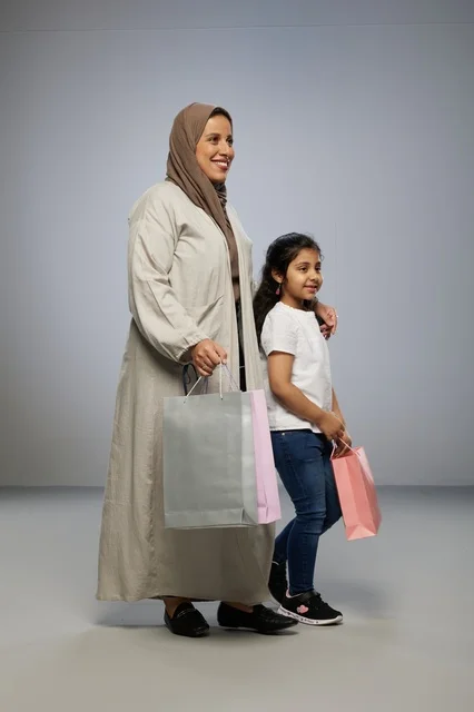 Saudi Mother and Daughter with Shopping Bags in Studio