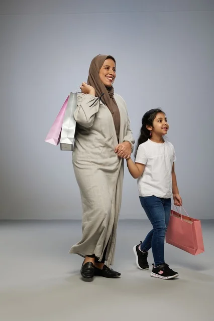 أم وابنتها السعوديتان تحملان أكياس التسوق