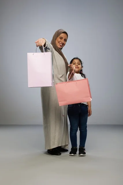 أم وابنتها سعوديتان تحملان أكياس التسوق في الاستوديو