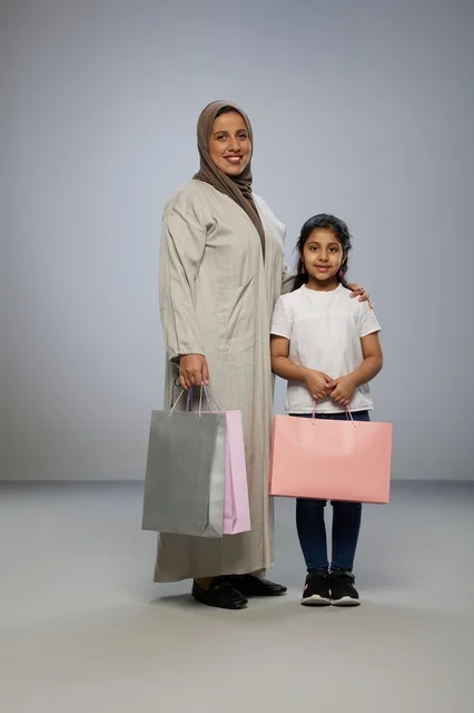 Saudi Mother and Daughter with Shopping Bags in Studio