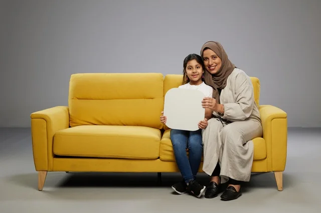 أم وابنة سعودية تحملان لوحة موك أب فارغة