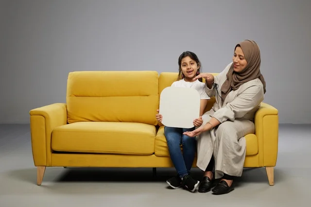 أم وابنتها سعوديتان مع لوحة موك أب فارغة