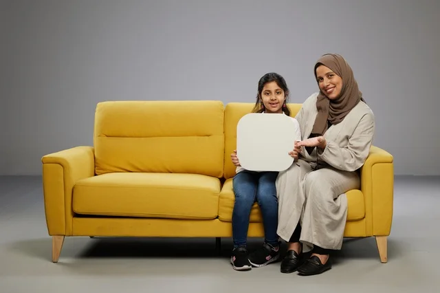 أم وابنتها السعوديتان تحملان لوحة موك أب فارغة