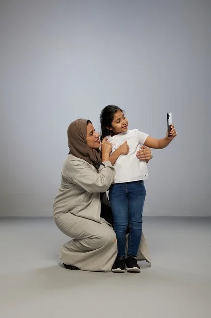 Saudi Mother and Daughter Taking Selfie on Smartphone