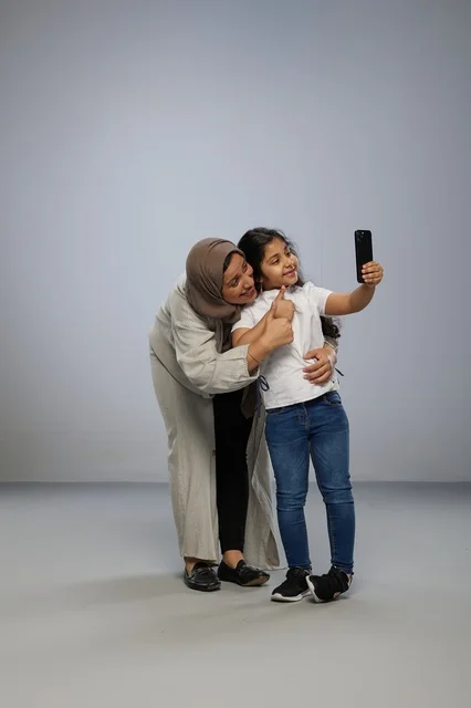 Saudi Mother and Daughter Taking Selfie in Studio