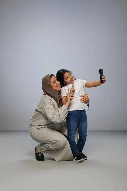 Saudi Mother and Daughter Taking Selfie in Studio