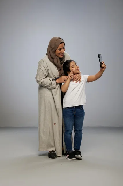 Saudi Mother and Daughter Taking Selfie on Smartphone