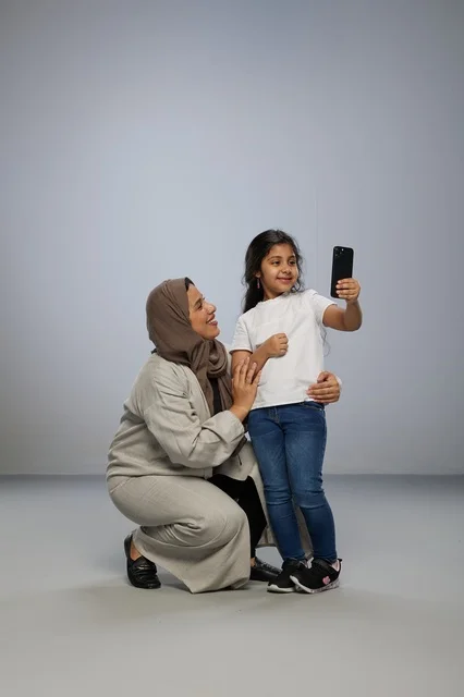 Saudi Mother and Daughter Taking Selfie in Studio
