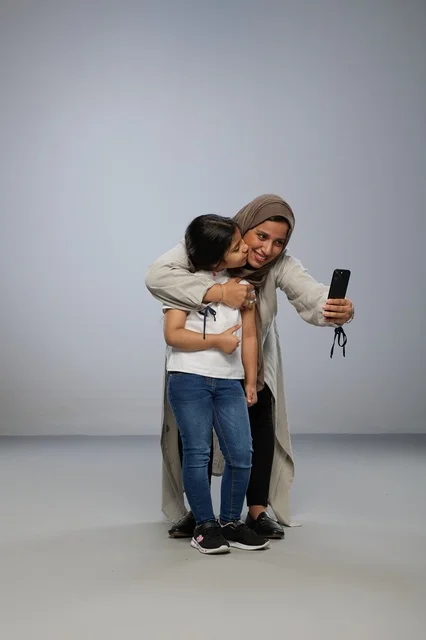Saudi Mother and Daughter Taking Selfie with Smartphone