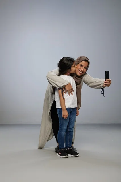 Saudi Mother and Daughter Taking Selfie in Studio