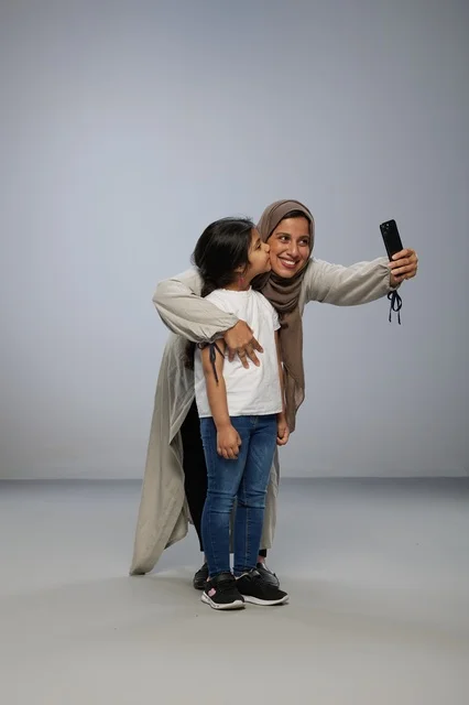 Saudi Mother and Daughter Taking Selfie in Studio