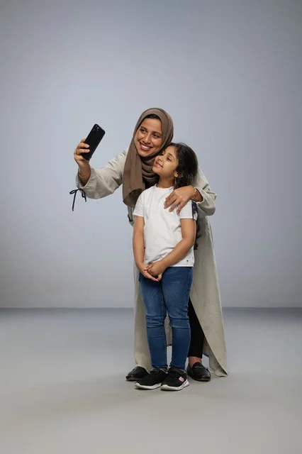 Saudi Mother and Daughter Taking Selfie in Studio
