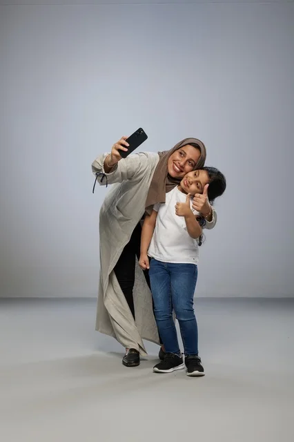 Saudi Mother and Daughter Taking Selfie in Studio