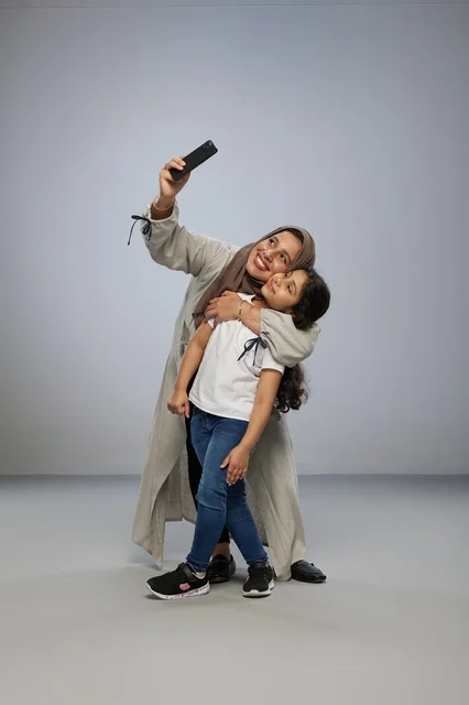 Saudi Mother and Daughter Taking Selfie in Studio