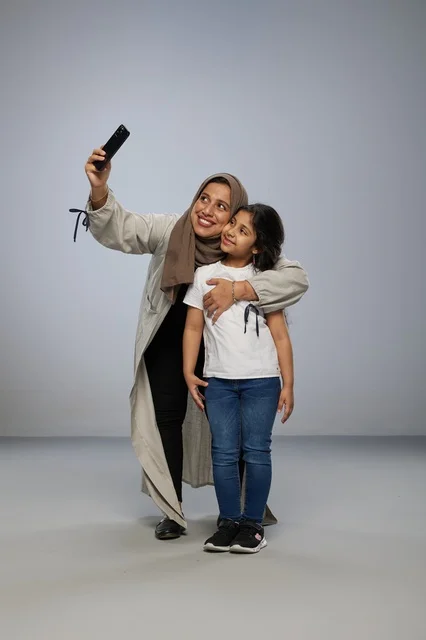 Saudi Mother and Daughter Taking Selfie in Studio