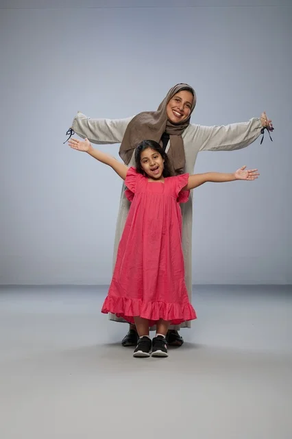 Smiling Saudi Mother and Daughter in Studio Setting