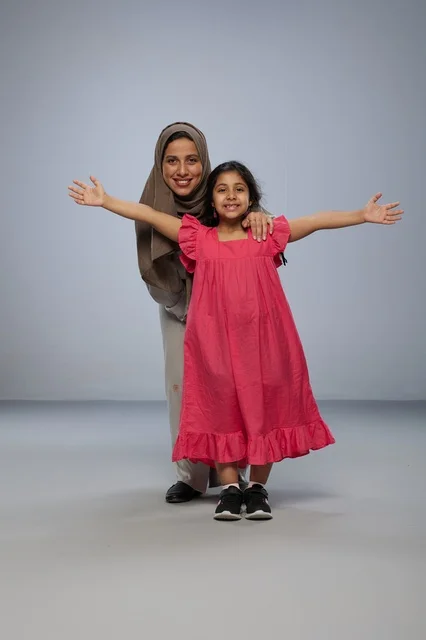 Saudi Mother and Daughter Smiling in Studio Portrait Saudi Mother and Daughter Smiling in Studio Portrait