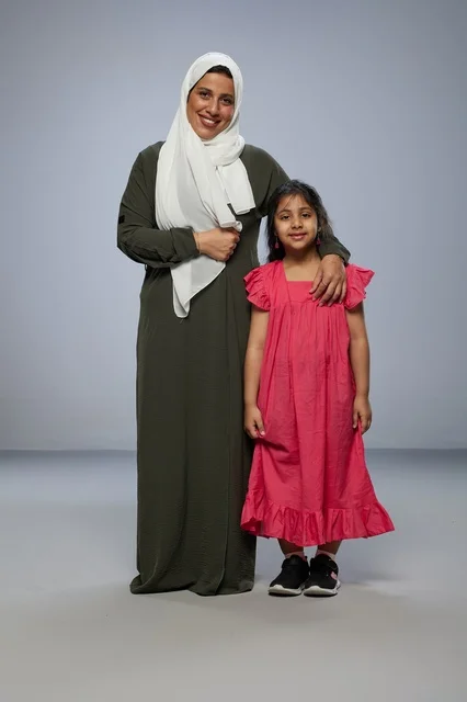 Saudi Mother and Daughter Studio Portrait on Gray Background