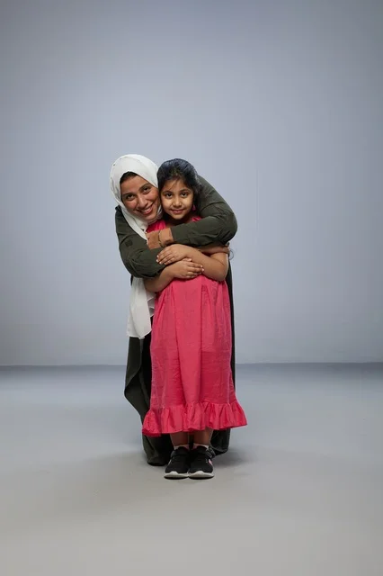 Saudi Mother and Daughter Hugging in Studio
