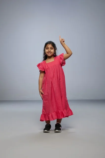 Saudi Girl in Pink Dress Pointing Upward in Studio