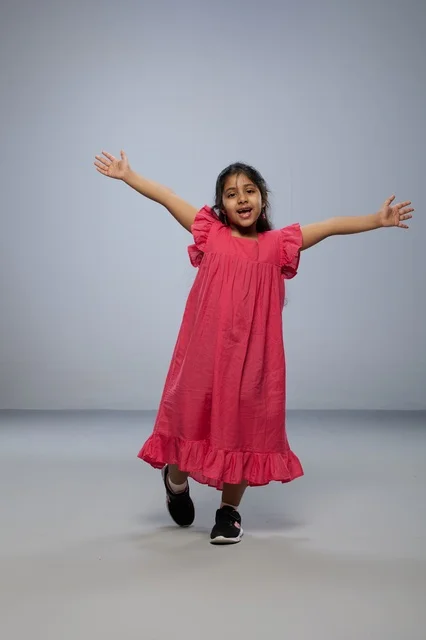 Happy Saudi Girl Jumping in Pink Dress Studio Portrait