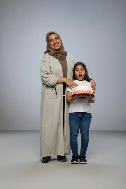 أم سعودية مع ابنتها وكعكة احتفال