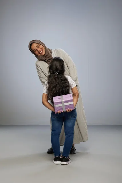 Arab Girl Hiding Purple Gift for Mother in Studio