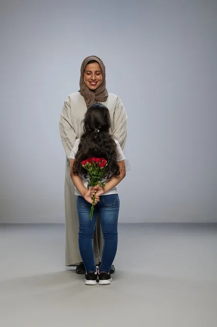 طفلة عربية تخفي الورود الحمراء لوالدتها في استوديو