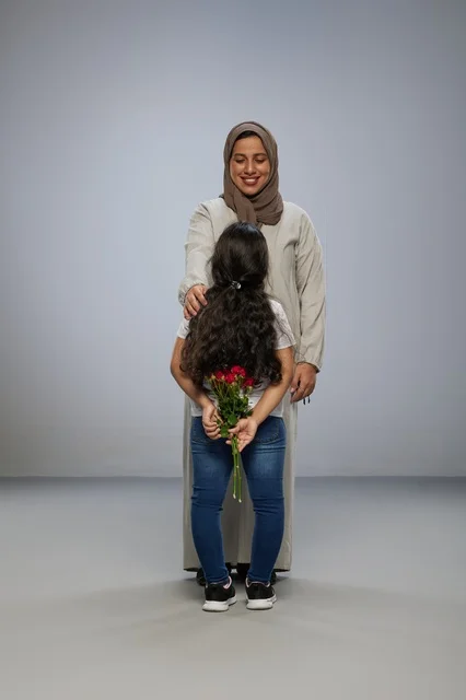 طفلة تخفي زهور حمراء لوالدتها في الاستوديو