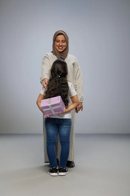 طفلة عربية تخفي هدية خلف ظهرها لوالدتها