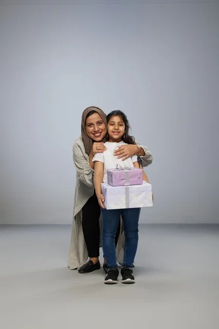 أم وابنتها مع صناديق هدايا في استوديو تصوير