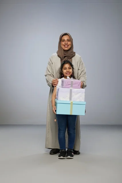 أم وطفلة عربية مع صناديق هدايا