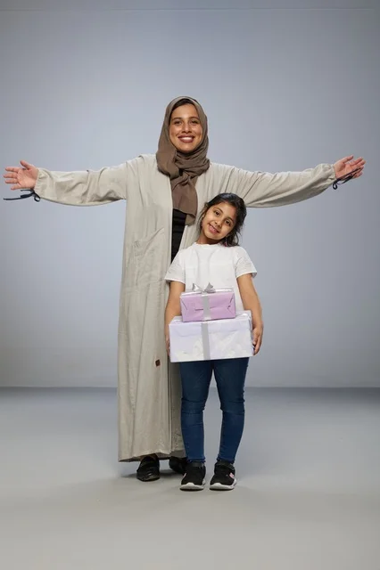 أم سعودية وابنتها مع صناديق هدايا في الاستوديو