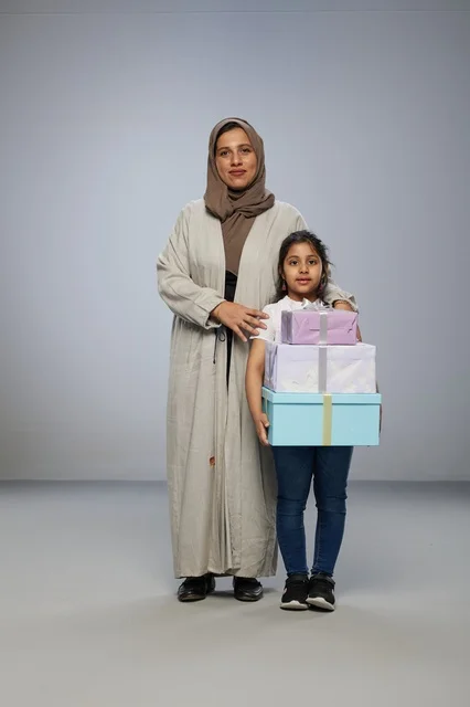 Arab Mother and Daughter Holding Gift Boxes in Studio